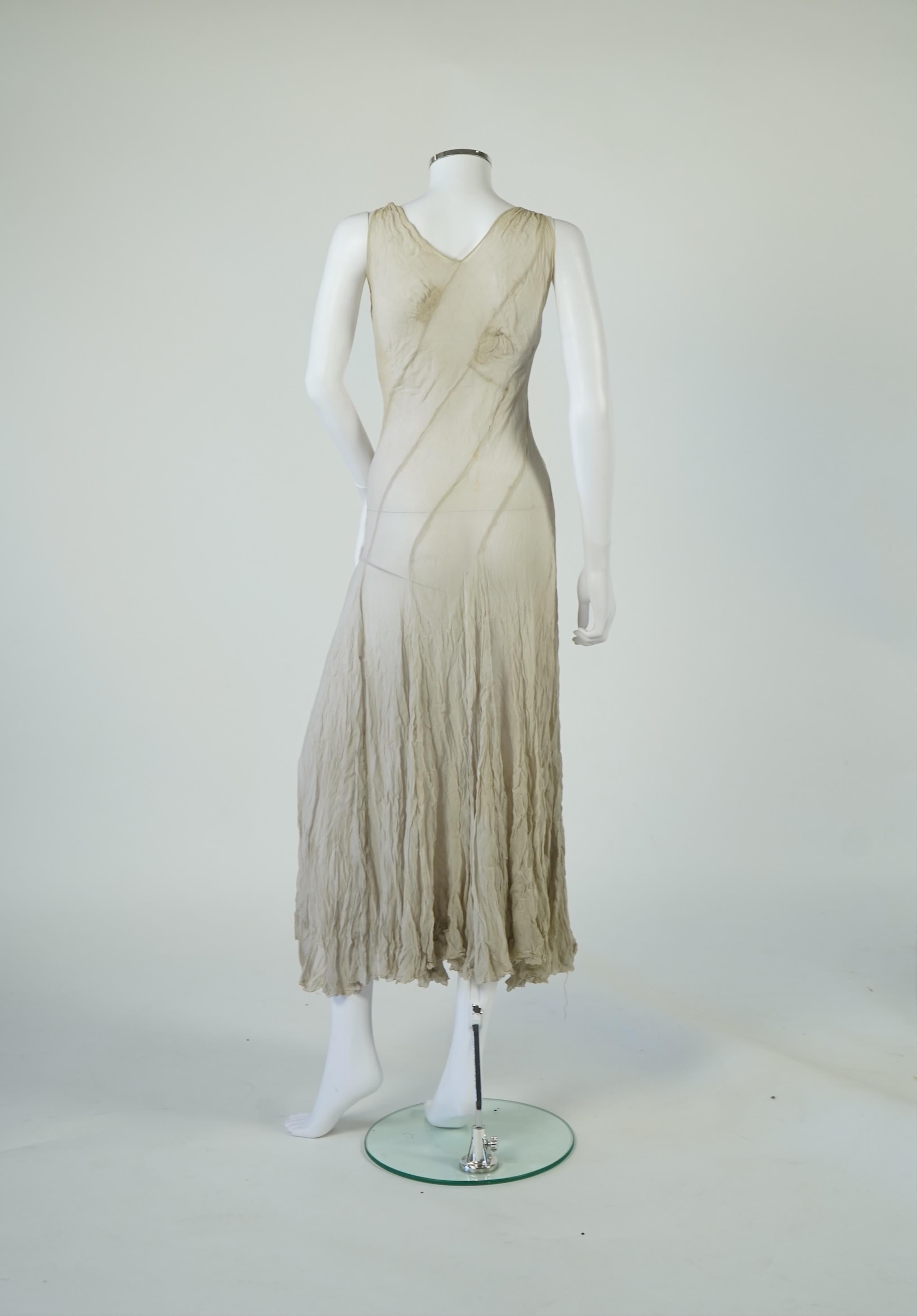 A 1930's grey chiffon bias cut ladies evening dress. 120cm long. Condition - has a small hole at the back and a light mark possibly removed with washing.